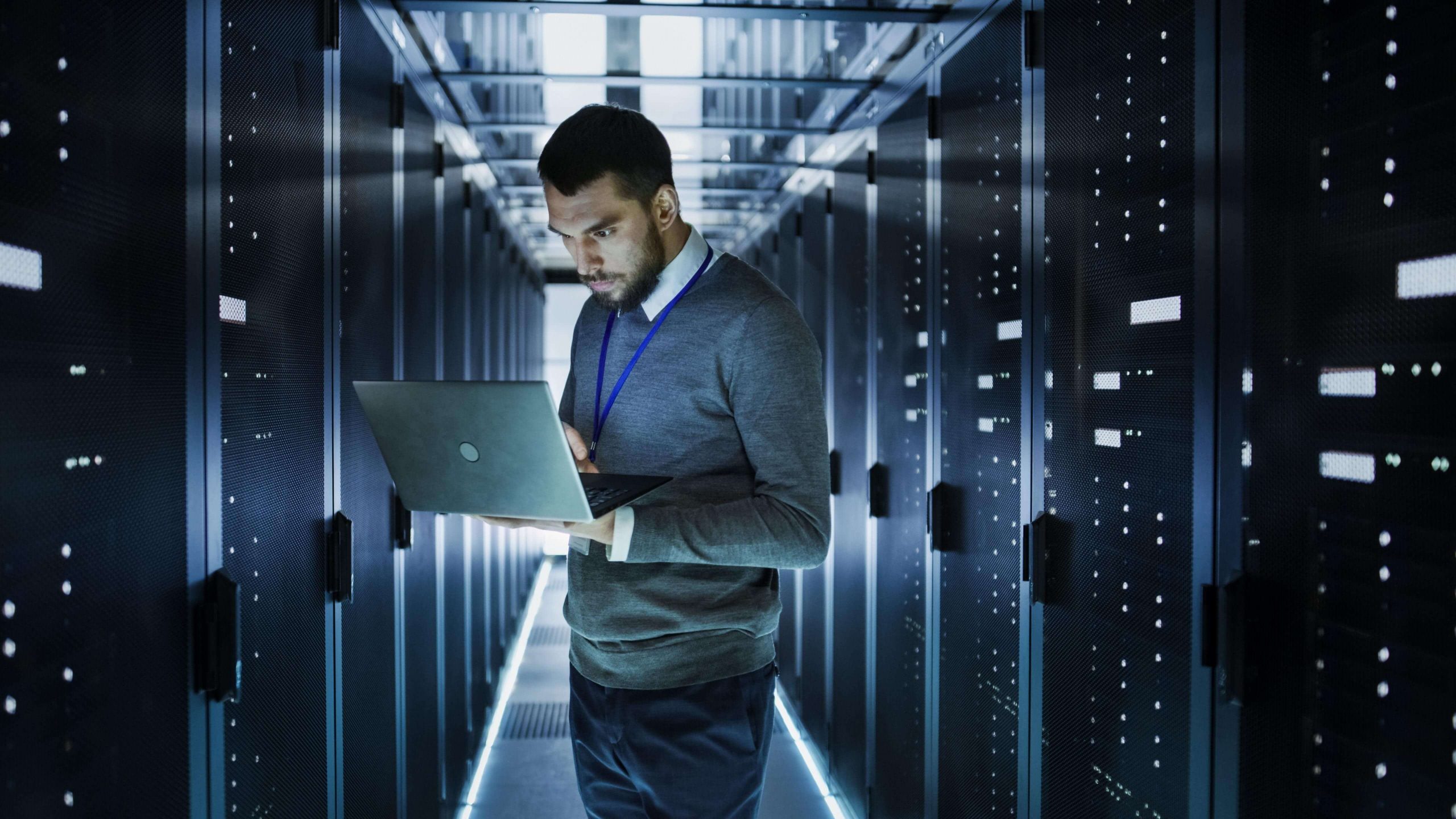 Techniker mit einem Laptop im Serverraum mit Fokus auf Database Boost